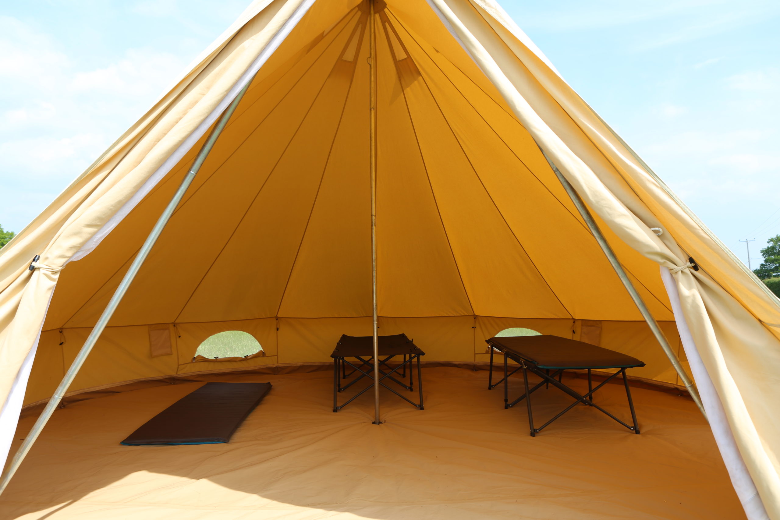 A 5m bell tent, highlighting the three different camp bed options offered.